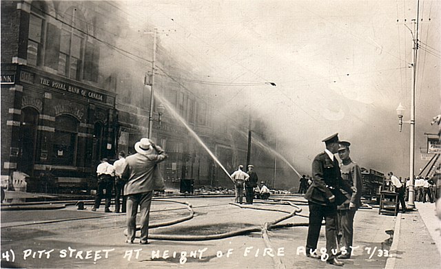 Firefighters with their hoses are seen here at the front of the buildings, Cornwall, Ontario 1933