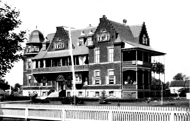 Cornwall General Hospital, Latticework and railings have been added under the porch at the right and a white picket fence has been installed.