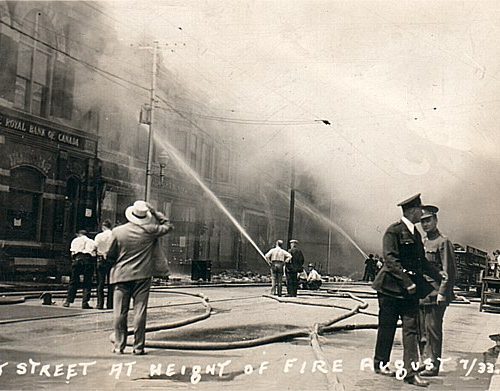 Firefighters with their hoses are seen here at the front of the buildings, Cornwall, Ontario 1933