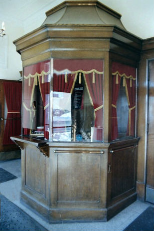 A formal ticket booth with curtains.