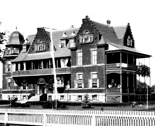 Cornwall General Hospital, Latticework and railings have been added under the porch at the right and a white picket fence has been installed.