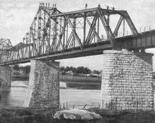 Workmen standing on completed bridge.